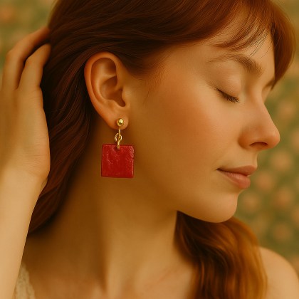 Κόκκινο σκουλαρίκι ρητίνης σε τετράγωνο σχήμα με χρυσή χαντρούλα φορεμένο